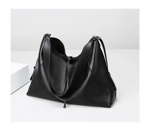 Detalle de la textura de cuero litchi negro y hebilla plateada en el bolso tote