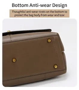 Detail view of the brown leather tote bag bottom with four golden protective metal studs