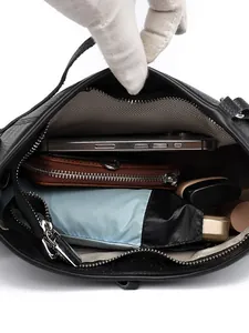 Black pebbled leather shoulder bag showing spacious interior with zipper and grey lining