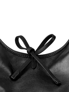 Primer plano del elegante lazo de cuero y las costuras finas del bolso tote negro