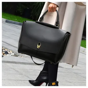 Close-up of black leather handbag with premium gold lock and protective base studs