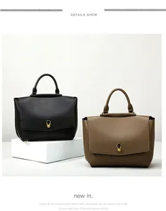 Close-up of minimalist leather handbags in black and brown with gold teardrop buckles