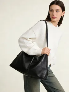 Bolso hobo minimalista de cuero negro con acabado texturizado para el trayecto diario