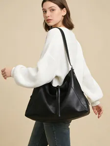 Detalle del bolso tote de cuero granulado negro en modelo con elegante cordón ajustable
