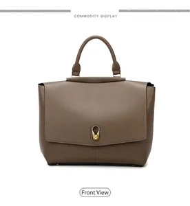 Close-up of vintage gold twist-lock on a premium brown leather handbag with flap cover