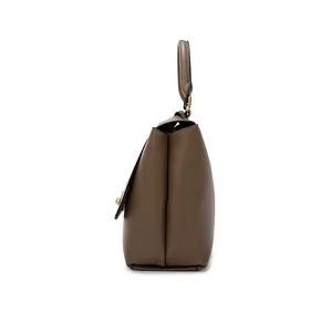 Side view of dark mocha leather handbag with minimalist trapezoidal design and gold hardware