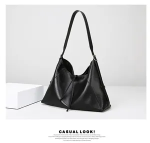 Detalle de bolso tote de cuero negro con cordón ajustable y textura suave brillante