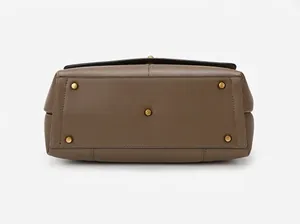 Detailed bottom view of brown leather handbag featuring five gold protective metal feet