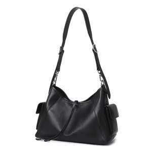 Detalle del bolso tote de cuero negro con bolsillos laterales y herrajes plateados