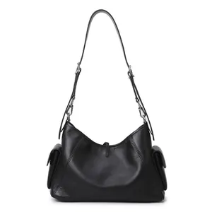 Detalle del bolso tote negro con bolsillos laterales con solapa y correa ajustable de cuero