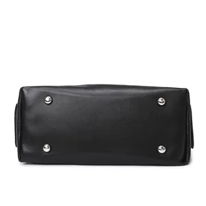 Vista inferior del bolso tote de cuero negro con cuatro pies de protección metálicos