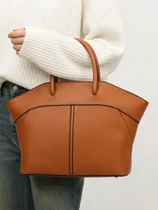 Brown leather wing-shaped tote bag with trapezoid design and large capacity for commuting