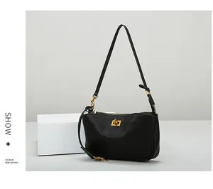 Detail einer minimalistischen schwarzen Ledertasche mit goldenem Verschluss und Reißverschluss
