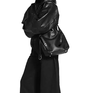 Close-up of black leather shoulder bag with silver buckle and natural slouchy texture