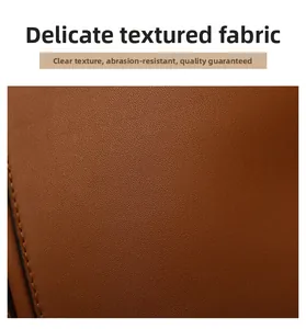 Close-up of brown litchi pattern leather with precise black stitching on a tote bag