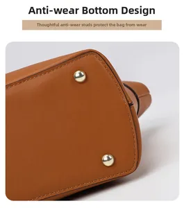 Close-up of golden metal feet on brown leather bag base for wear protection