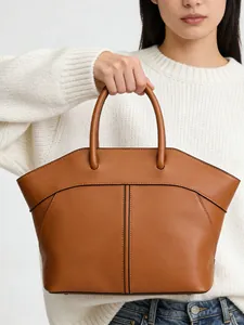 Brown leather tote bag featuring elegant curved stitching and twin handles for commute