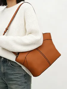 Detail of caramel tote bag with black geometric outlines and adjustable strap
