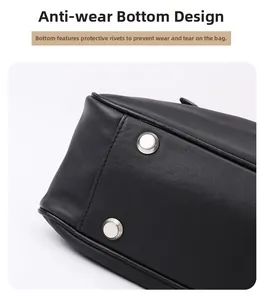 Detail of black leather handbag bottom with silver protective metal rivets and stitching
