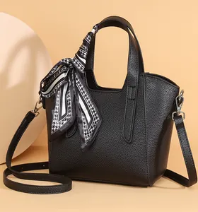 Détail du sac seau en cuir noir texturé avec un foulard en soie élégant décoratif
