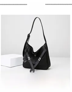 Close-up of black leather shoulder bag with silver hardware and adjustable wide strap