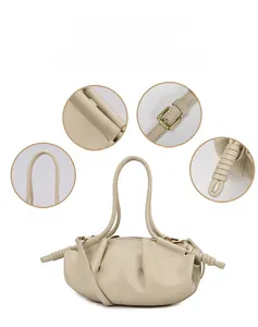 Détails des coutures soignées et de la boucle dorée sur un sac nuage beige