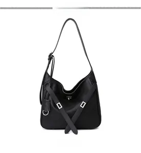 Close-up of black leather hobo bag with silver buckles and adjustable shoulder strap