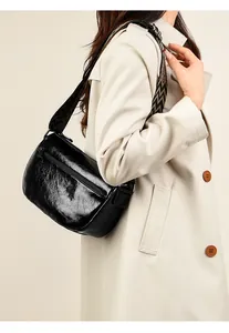 Détail du sac en cuir plissé noir brillant avec bandoulière large à motifs géométriques