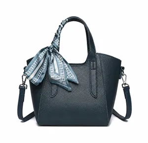 Vista frontale della borsa a secchiello in pelle martellata blu navy con foulard decorativo