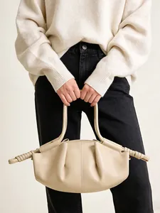 Détail du sac nuage minimaliste crème avec cuir plissé et poignées à détails enroulés