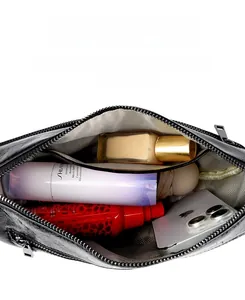 Vue intérieure du sac bandoulière en cuir noir montrant sa grande capacité et sa doublure