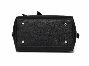 Dettaglio del fondo della borsa in pelle martellata nera con quattro piedini di metallo