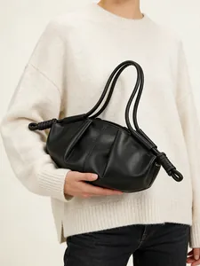 Sac nuage en cuir noir minimaliste avec détails noués et doubles anses sur modèle
