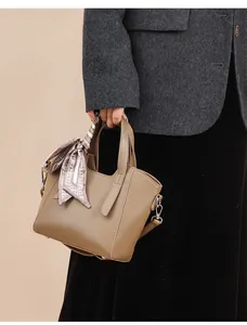 Détail du sac seau en cuir grainé kaki avec foulard en soie décoratif sur la poignée