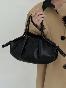 Gros plan du sac nuage en cuir noir froncé avec des plis doux et des détails de nœuds