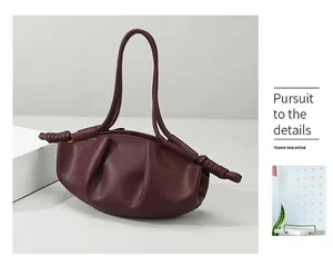 Détails du sac nuage en cuir souple bordeaux avec poignées nouées et texture plissée
