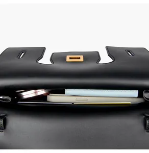 Top view of black leather bag showing interior storage with phone, wallet and mirror