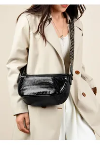 Détail du sac hobo en cuir noir avec une bandoulière tissée à motifs géométriques