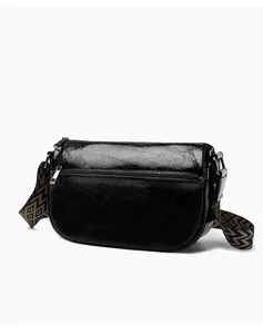 Vue latérale du sac bandoulière en cuir noir brillant avec bandoulière à motifs rétro