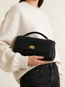 Elegant black leather handbag with gold twist lock and structured top handle for women