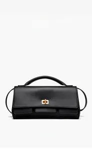 Close-up of elegant black leather handbag with a golden twist-lock and top handle