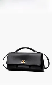 Detailed view of the black leather handbag featuring a prominent gold square twist lock