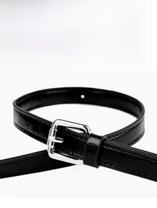 Detail of adjustable black leather strap with silver metal buckle for crossbody bag