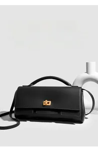 Detail of black leather handbag with gold twist lock and elegant top handle