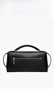 Macro shot of smooth black leather handbag featuring gold zipper and textured finish
