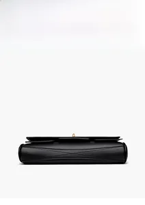 Detail of black leather handbag featuring reinforced cross stitching and gold twist lock