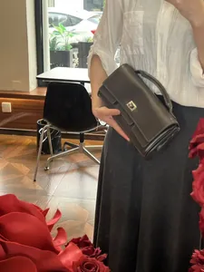Detail of elegant dark grey leather handbag with silver twist lock and top handle grip
