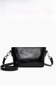 Detailed front view of black crossbody bag with cracked glossy leather and silver hardware