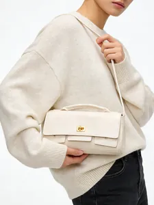 Detail view of cream shoulder bag with gold twist lock and fine leather texture