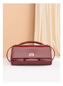 Close-up of wine red leather handbag featuring a premium gold rectangular twist lock